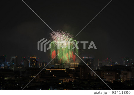 真夏の東京のビル群と夜空を彩る花火大会 93411800
