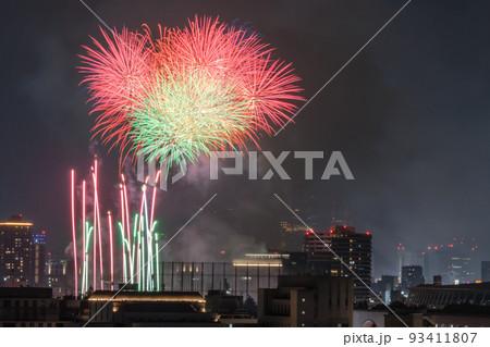 真夏の東京のビル群と夜空を彩る花火大会 93411807