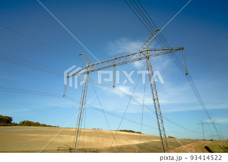 Steel pillar with high voltage electric power lines delivering electrical energy through cable wires on long distance Steel pillar with high voltage electric power lines delivering electrical energy through cable wires on long distance 93414522