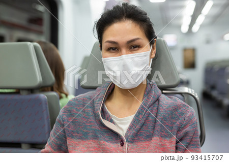 Woman in protective mask sitting in subway train 93415707
