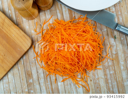 Pile of fresh shredded carrot on table 93415992