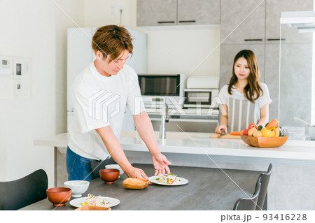 食事の準備を手伝う男性と女性（夫婦） 93416228