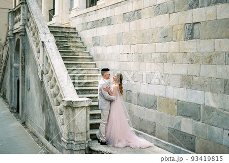 Bride hug groom on the stone steps of an old building. Bergamo, Italy 93419815
