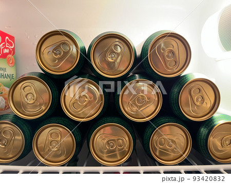 Lot of aluminum cans of beer lie in the refrigerator 93420832