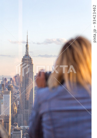 Rear View of Woman Peering Through Binocular View Finder at New York Skyline from Top of the Rock Rear View of Woman Peering Through Binocular View Finder at New York Skyline from Top of the Rock 93423462