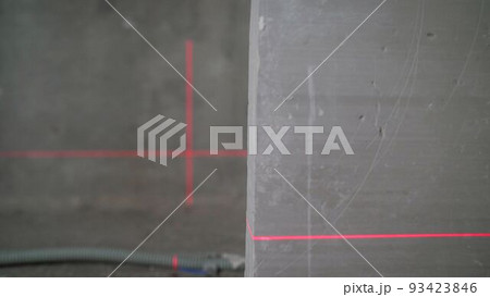 Leveling the wall with a laser level. Lighted laser level. Display perpendicular lines. Laser on the walls in preparation for leveling the floor. Laser level flooring Leveling the wall with a laser level. Lighted laser level. Display perpendicular lines. Laser on the walls in preparation for leveling the floor. Laser level flooring 93423846