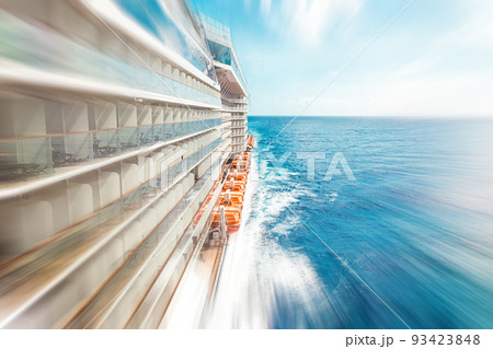 Side view of cruise ship on the blue sky background with copy space, blue tone with motion blur effect Side view of cruise ship on the blue sky background with copy space, blue tone with motion blur effect 93423848