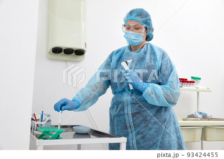 Doctor in a protective suit taking a swab from a patient to test for possible coronavirus or covid infection 93424455