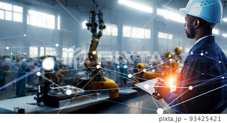 近未来の工場でロボットをタブレットで遠隔操作するエンジニア 近未来の工場でロボットをタブレットで遠隔操作するエンジニア 93425421