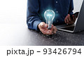ネットワークテクノロジーとビジネスのアイディアのイメージ。青く光る電球とスマートフォンを持つ男性。ノ 93426794