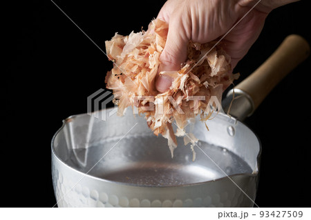 鰹節を鍋に入れる 93427509