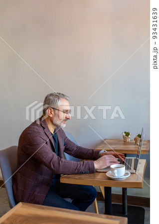 Businessman working in a cafe and looking seriosu 93431639
