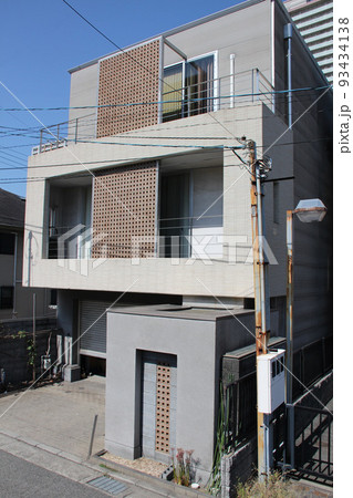 青空に映えるアースカラーのキューブ型の都市型3階建ての穴あきレンガブロックスクーリンがある美しい邸宅 青空に映えるアースカラーのキューブ型の都市型3階建ての穴あきレンガブロックスクーリンがある美しい邸宅 93434138