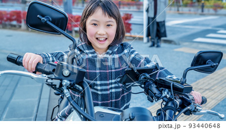 親の大型バイクに跨って喜ぶ小学生 93440648