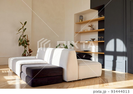 Spacious living room interior with comfy couch and various decorative elements Spacious living room interior with comfy couch and various decorative elements 93444013