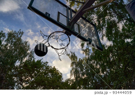 Street basketball ball falling into the hoop. Street basketball ball falling into the hoop. 93444059