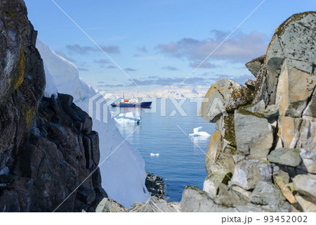 Expedition ship with iceberg in Antarctic sea aerial view  93452002