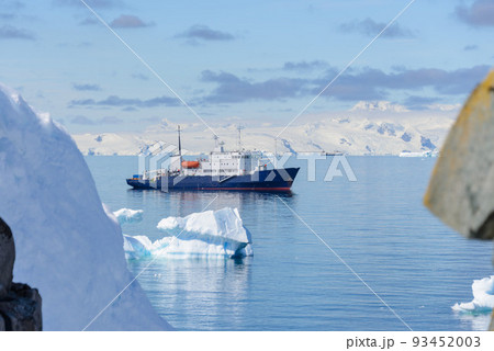 Expedition ship with iceberg in Antarctic sea aerial view  93452003