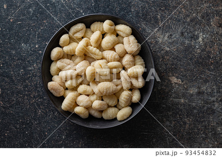 Uncooked potato gnocchi in bowl. Tasty italian food. 93454832