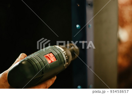 Male hand holding screwdriver. Worker uses construction tool for 93458657