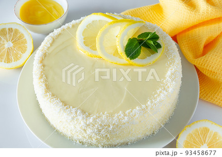 Lemon cake with coconut flakes and white cream, vanilla holiday dessert. Lemon cake with coconut flakes and white cream, vanilla holiday dessert. 93458677