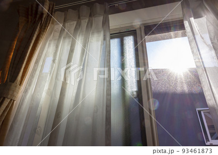 窓から部屋に差し込むまぶしい太陽の光 93461873