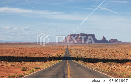 Scenic Road in the Dry Desert with Red Rocky Mountains in Background 93461897