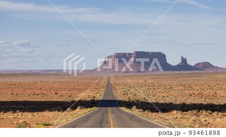 Scenic Road in the Dry Desert with Red Rocky Mountains in Background 93461898