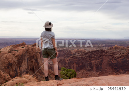 Adventurous Woman Hiking at a Desert Canyon with Red Rock Mountains. 93461939