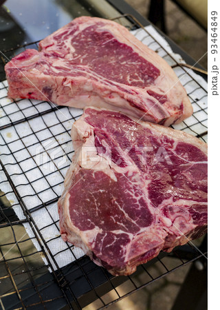 Close up of Fresh cut, raw T-bone steak prepared for cooking on the grill Close up of Fresh cut, raw T-bone steak prepared for cooking on the grill 93464849