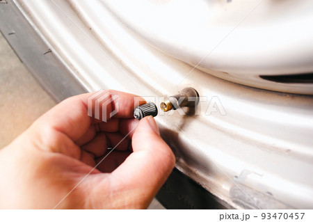 The car driver manually remove the tire valve cap 93470457
