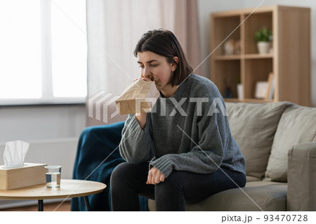 woman having panic attack breathing to bag at home woman having panic attack breathing to bag at home 93470728