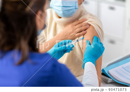 nurse with syringe making injection to woman nurse with syringe making injection to woman 93471073