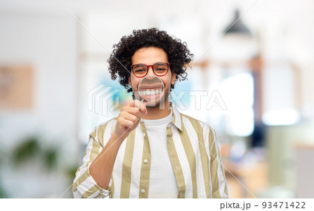 man showing his teeth through magnifying glass man showing his teeth through magnifying glass 93471422