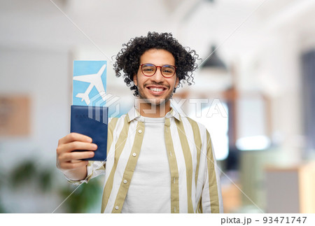 smiling man with passport and air ticket at office 93471747