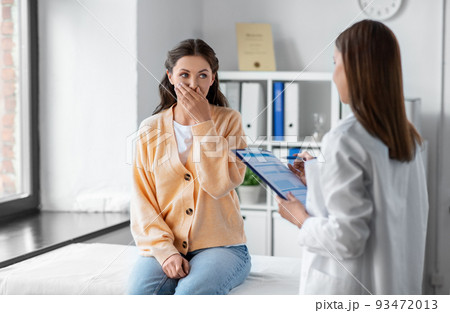 female doctor and coughing woman at hospital 93472013
