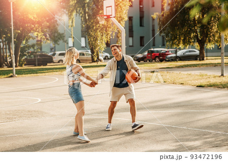 happy couple with ball on basketball playground happy couple with ball on basketball playground 93472196