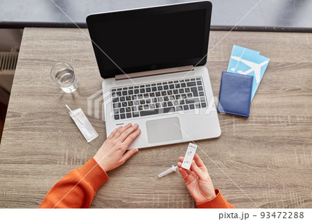 woman with laptop making coronavirus test at home 93472288