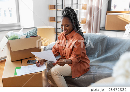 woman with bills and calculator moving to new home 93472322