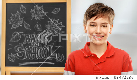 happy smiling student boy over chalkboard 93472536