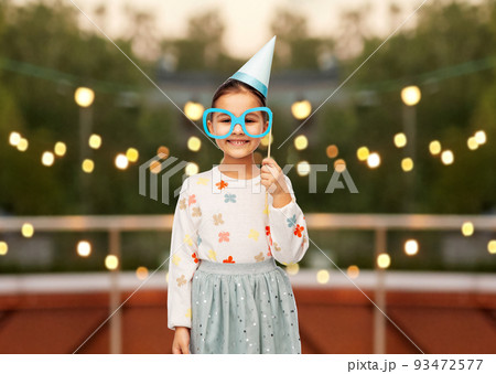 little girl in birthday party hat with glasses little girl in birthday party hat with glasses 93472577