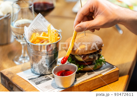 close up of hand dipping french fries to ketchup close up of hand dipping french fries to ketchup 93472611