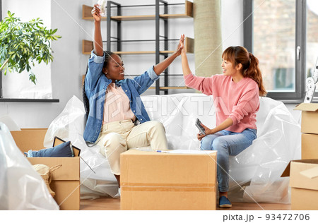 happy women moving to new home and counting money happy women moving to new home and counting money 93472706