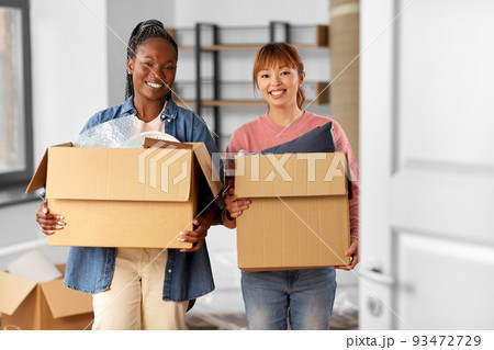 women with boxes moving to new home 93472729