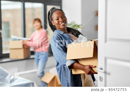 women with boxes moving to new home 93472755