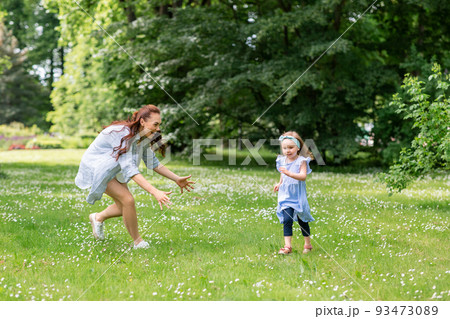 happy mother with little daughter playing at park 93473089
