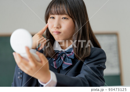学校の教室で休み時間に鏡を見る女子高生 学校の教室で休み時間に鏡を見る女子高生 93473125
