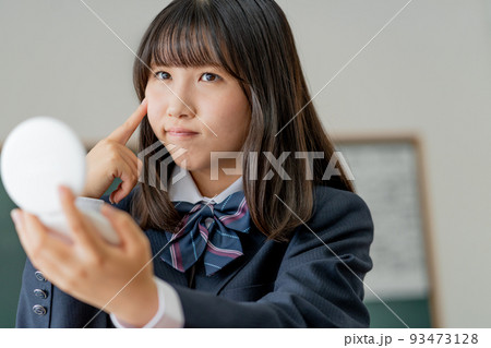 学校の教室で休み時間に鏡を見る女子高生 学校の教室で休み時間に鏡を見る女子高生 93473128