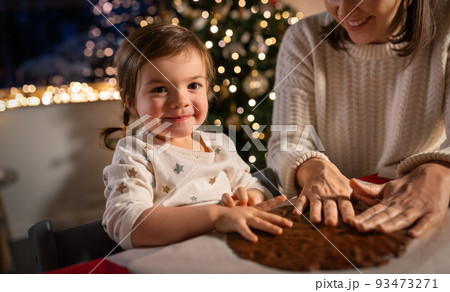 mother and daughter making gingerbread at home 93473271