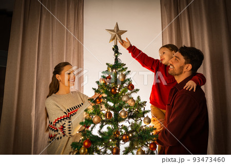 happy family decorating christmas tree at home 93473460